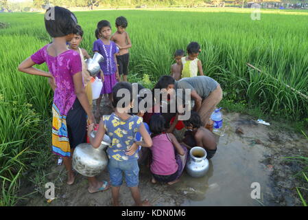 Enfants Rohingyas sont recueille l'eau de la rizière à l'balukhali camp à Cox's bazar, Bangladesh, le 10 octobre 2017 selon l'ONU. Banque D'Images