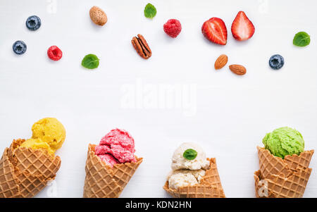 La crème glacée coloré avec les cônes et divers fruits bleuets Fraises Framboises ,,et feuilles de menthe poivrée setup sur fond blanc télévision lay et copier s Banque D'Images