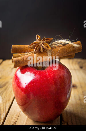 Bâtons de cannelle apple brillant rouge attaché avec de la ficelle étoile d'anis sur fond de bois. vintage style rustique. symbole de noël nouvelle année. Carte de souhaits poster Banque D'Images