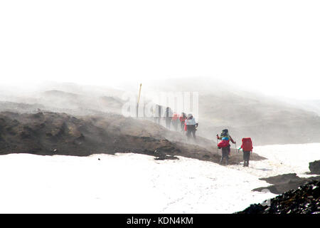 Les randonneurs traversant le champ de neige à travers la brume sur glacier Eyafjallajokull, Islande Banque D'Images