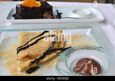 Décorées avec des miettes de crêpes et de chocolat sur plaque de verre avec un dessert au chocolat avec plaque Banque D'Images