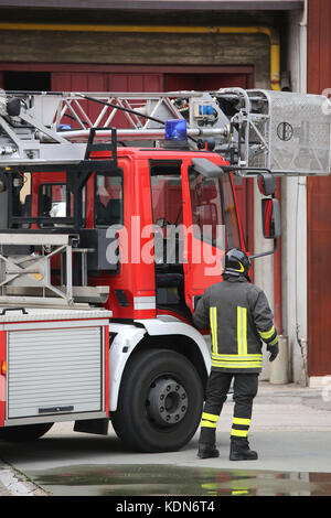 Pompier et un camion de pompiers à la caserne au cours d'un exercice incendie Banque D'Images