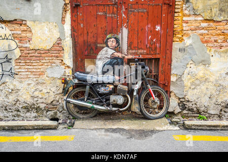 Penang, Malaisie - 21 mai 2016 : la peinture d'un garçon assis sur une vieille moto à George Town, Penang, Malaisie. Banque D'Images