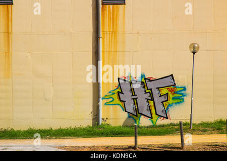 Graffitis coloré et artistique sur un mur crème lastié à Albuferia au Portugal Banque D'Images