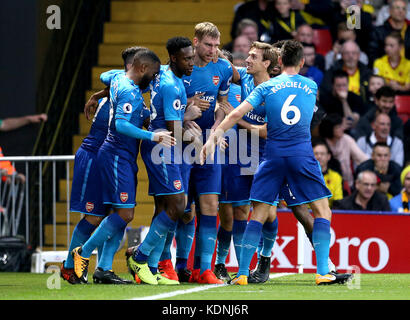 Le Per Mertesacker d'Arsenal (au centre) célèbre avoir marqué le premier but de son équipe lors du match de premier League à Vicarage Road, Watford. Banque D'Images