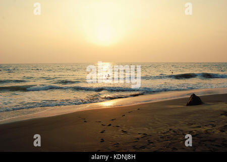 Plage tropicale et l'océan pacifique. De photo. Les touristes profiter de la mer au coucher de soleil. Coucher du soleil sur la plage de Varkala, Kerala, Inde. Banque D'Images