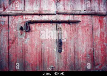 Portes de grange avec une vis rouillée. Nord de la Russie. Verrouillage des portes rouge rouge avec peinture pelée. Kenozersky Parc National (réserve de biosphère de l'UNESCO), Russ Banque D'Images
