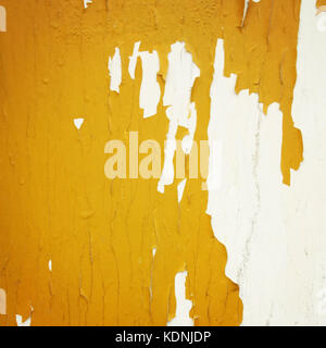 La peinture jaune vif sur la surface blanche. L'écaillage de la peinture sèche. L'espace de copie pour le texte. La photo en gros plan. La tonalité de l'image. Lieu abandonné. Grunge fond. Banque D'Images