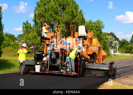 Travailleurs sur une machine à asphalter posant de nouvelles routes dans un quartier résidentiel en Floride Banque D'Images