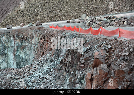 En vue d'une carrière de roches de porphyre mine rouge clôture de sécurité. Banque D'Images