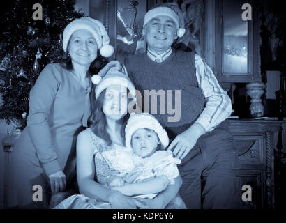 Imitation de vintage photo de famille heureuse de trois générations au moment de Noël ou de la saison de vacances Banque D'Images