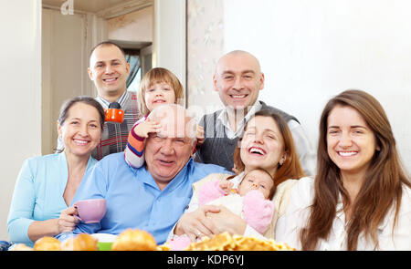 Portrait de famille multigénérationnelle heureux communiquer sur un plateau à la maison Banque D'Images