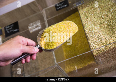 Vue sur boulgour cru pris avec scoop métallique en poids de vente en magasin alimentaire Banque D'Images