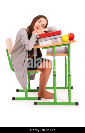 L'éducation, personnes, adolescent et adolescent - concept de l'école école fille dormir sur un livre à son bureau isolated on white Banque D'Images