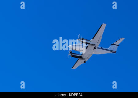 Twin turbo prop en approche finale contre un ciel d'été bleu clair Banque D'Images