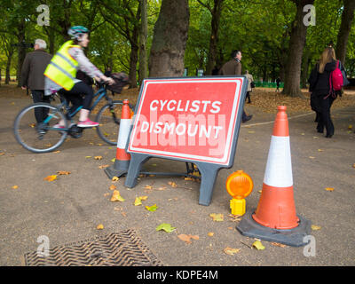 Les cyclistes ignorer le signe qui leur enjoint de sortir de leurs bicyclettes Banque D'Images
