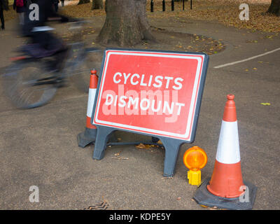 Les cyclistes ignorer le signe qui leur enjoint de sortir de leurs bicyclettes Banque D'Images