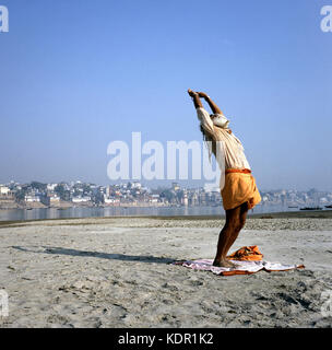 L'Inde, Varanasi, sadhu indien d'effectuer une salutation (yoga) sur les rives du Gange Banque D'Images