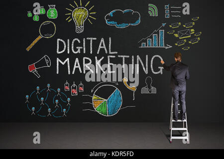 Vue arrière du businessman standing on staircase dessin digital marketing concept sur tableau noir