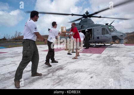 Les Marines et les volontaires américains déchargent des fournitures d'urgence d'un hélicoptère UH-1Y Venom Super Huey du corps des Marines des États-Unis pendant les efforts de secours au lendemain de l'ouragan Irma le 11 septembre 2017 à l'occasion de John, Îles Vierges américaines. Banque D'Images