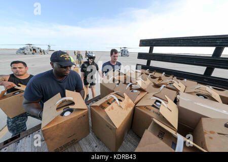 Les marins de l'US Navy chargent des fournitures d'urgence sur un camion à la base aérienne navale de Key West pendant les efforts de secours après l'ouragan Irma le 11 septembre 2017 à Key West, en Floride. Banque D'Images