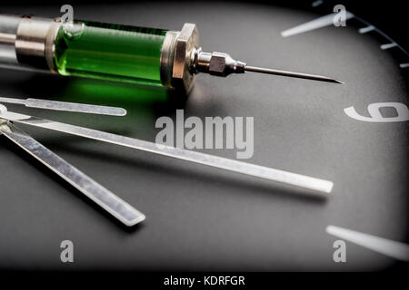 Une seringue d'une horloge en laboratoire, conceptual image Banque D'Images