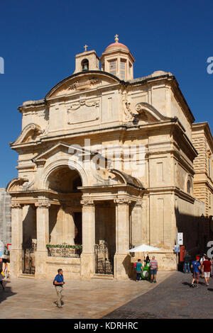 Valette, Malte, Europe. Les gens qui marchent devant l'église de Sainte Catherine d'Alexandrie (également connue sous le nom d'église de Sainte Catherine d'Italie). Banque D'Images