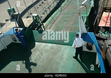 Le traversier niso, Danemark - 6 août 2009 : l'officier et un marin déposer la passerelle que le ferry quitte le port. Banque D'Images