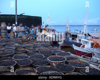 De nombreux paniers remplis d'acai acai en marché arrivant à Belém, Brésil, vue sur le fleuve et les bateaux Banque D'Images