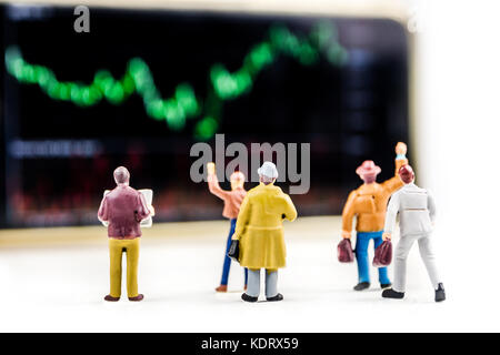 Concept d'affaires, gros plan de miniatures d'hommes debout devant l'écran avec un grand prix de l'action graphique du marché avec l'indicateur Banque D'Images