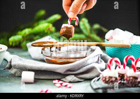 Trempant dans un bain de guimauve chocolatte. creative friandises de Noël. Banque D'Images