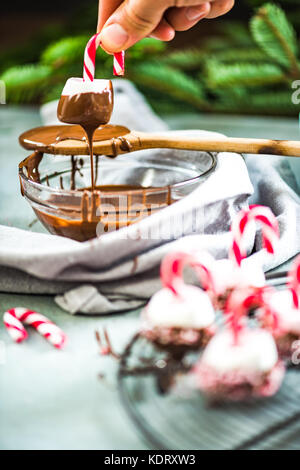 Trempant dans un bain de guimauve chocolatte. creative friandises de Noël. Banque D'Images