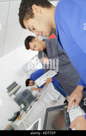 Jeune homme réparation technicien photocopieur numérique machine Banque D'Images