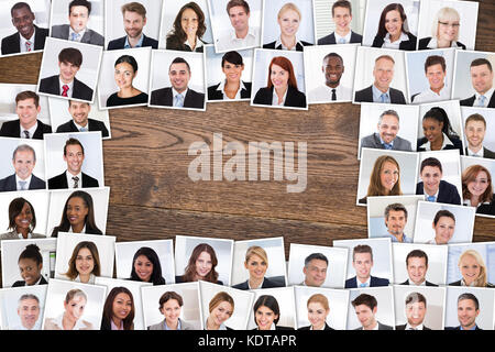 Vue en grand angle des photos de personnes d'affaires multiethniques souriantes Portraits Collage sur une table en bois. Banque D'Images