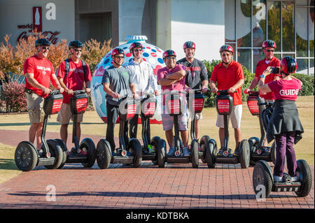 Segway tour group posant pour une photo en face du monde de Coca-Cola au centre-ville d'Atlanta, Géorgie. (USA) Banque D'Images