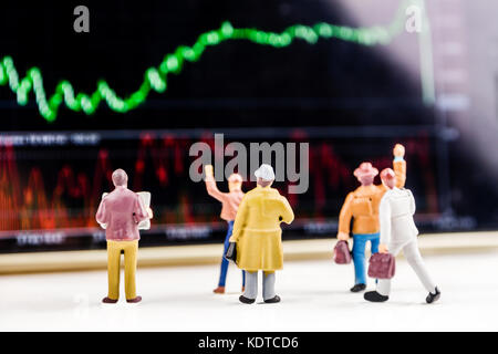 Concept d'affaires, gros plan de miniatures d'hommes debout devant l'écran avec un grand prix de l'action graphique du marché avec l'indicateur Banque D'Images