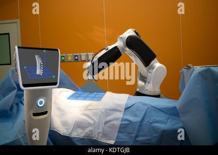 Le robot sous-utilisation de la technologie médicale pour la numérisation d'un patient avant de la colonne vertébrale et d'envoyer les données de 3d de la moelle au moniteur sur le robot il aide Banque D'Images