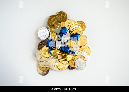 Pile des dreidels colorés et hanukkah coins isolated on white Banque D'Images