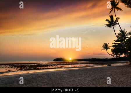 Magnifique lever de soleil sur plage de sable sur l'île de Bintan en Indonésie avec silhouette de cocotiers avec copie espace. Banque D'Images