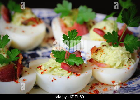 Oeufs farcis apéritif avec avocat et bacon Banque D'Images