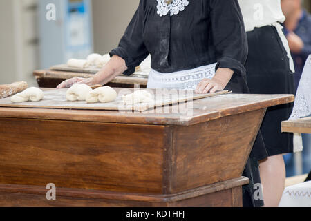 Asti, ITALIE - 10 septembre 2017 : femme frappe et formes farine pour faire du pain Banque D'Images