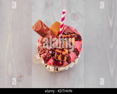 Freakshake avec donuts sur fond de bois gris Banque D'Images