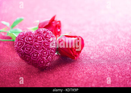 En forme de coeur scintillant avec des roses sur fond rose Banque D'Images
