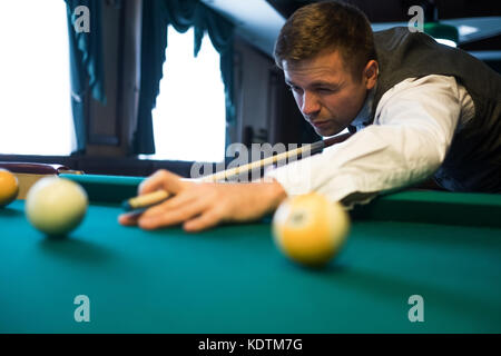 Young man playing billiards prêt à tirer. Banque D'Images