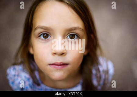 Portrait de petite fille à la recherche jusqu'à la maison mère à l'extérieur. un enfant est de la recherche vers la caméra en extérieur dans les bois. faible profondeur de champ et s Banque D'Images