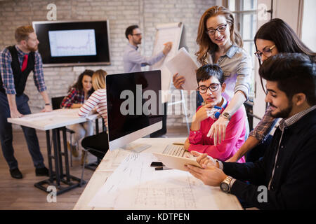 Groupe de jeunes designers en vue de discuter du bureau Banque D'Images