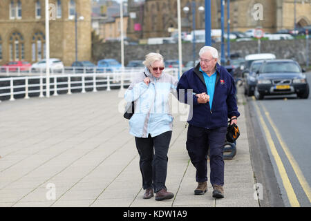 Aberystwyth, Ceredigion, pays de Galles, Royaume-Uni. 16 oct, 2017. uk weather. Un d'âge mûr trouvent difficile comme ils marcher le long de la promenade dans les forts vents à Aberystwyth, sur la côte ouest du pays de galles comme approches ophelia tempête au large de la mer d'irlande. photo steven mai / alamy live news Banque D'Images