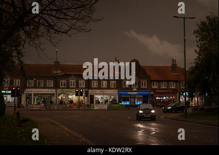 La nuit tombe comme une voiture conduit par Norfolk Arms dans le West Sussex, Angleterre. Le ciel s'est assombri et une étrange lueur orange est apparu dans le milieu de la journée. L'éclairage de rue est venu sur et les pilotes ont dû mettre leurs phares allumés. Le phénomène d'après les rapports a été causée par l'ex-ouragan, tempête Ophelia, tirant dans l'air et la poussière de l'Europe du sud et en Afrique. Banque D'Images