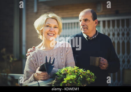 L'homme et de la femme à la retraite dans un jardin patio à proximité de leur domicile Banque D'Images