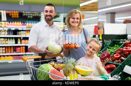 Cheerful family shopping divers légumes frais au supermarché.focus sur la fille Banque D'Images